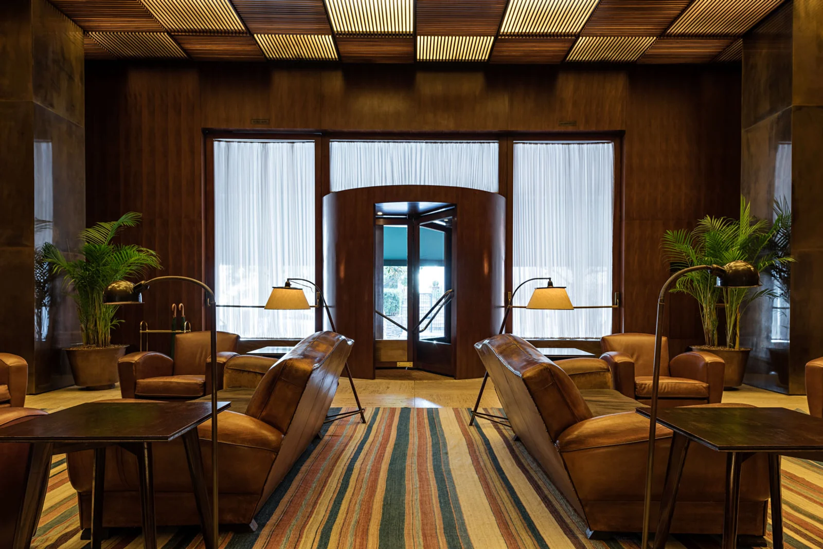 Lobby do primeiro Hotel Fasano em São Paulo com madeira, couro e iluminação discreta