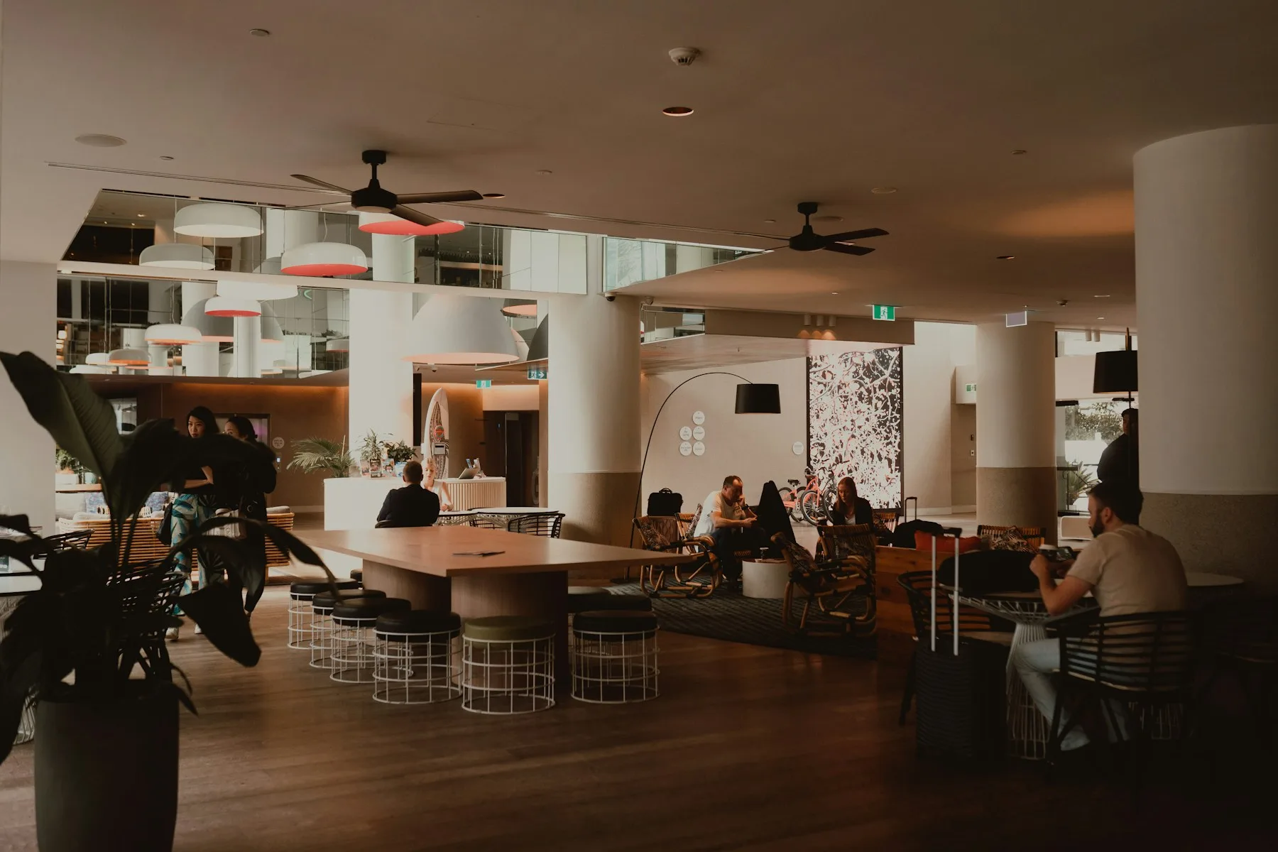Hóspedes e equipe em um lobby contemporâneo de hotel