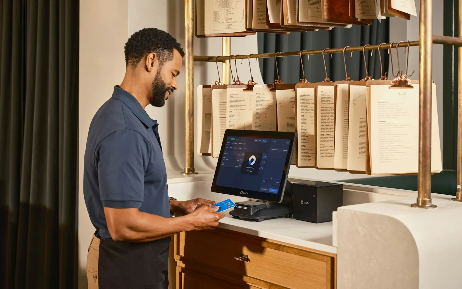 Profissional opera um terminal de pagamento em um restaurante