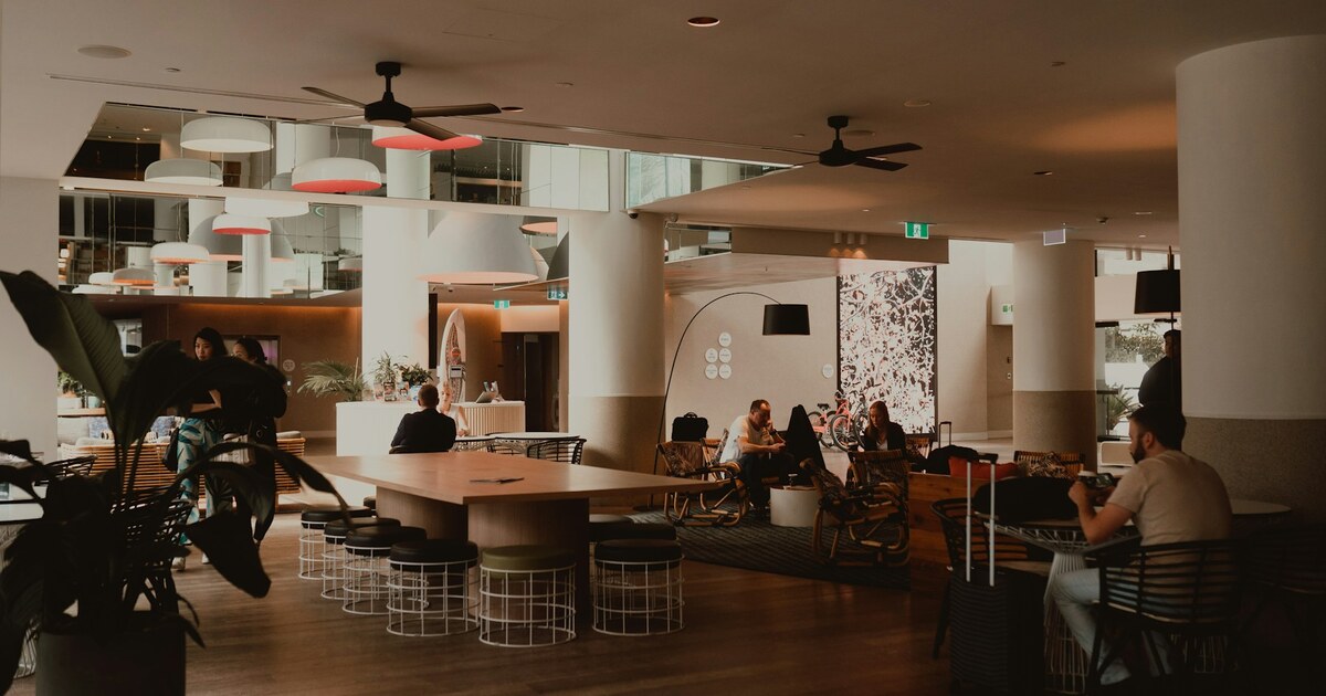 Hóspedes e equipe em um lobby contemporâneo de hotel