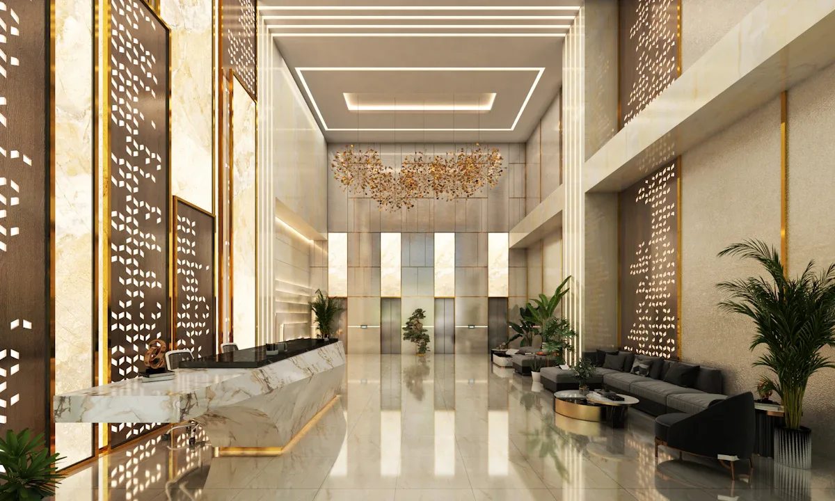 Lobby de hotel com balcão de recepção e área de estar.